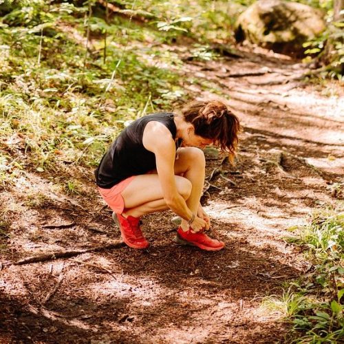 Femme en traind e faire de la course à pied en forêt