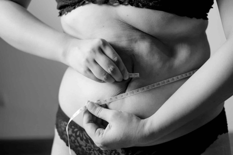 Femme mesurant son tour de taille avec un mètre ruban